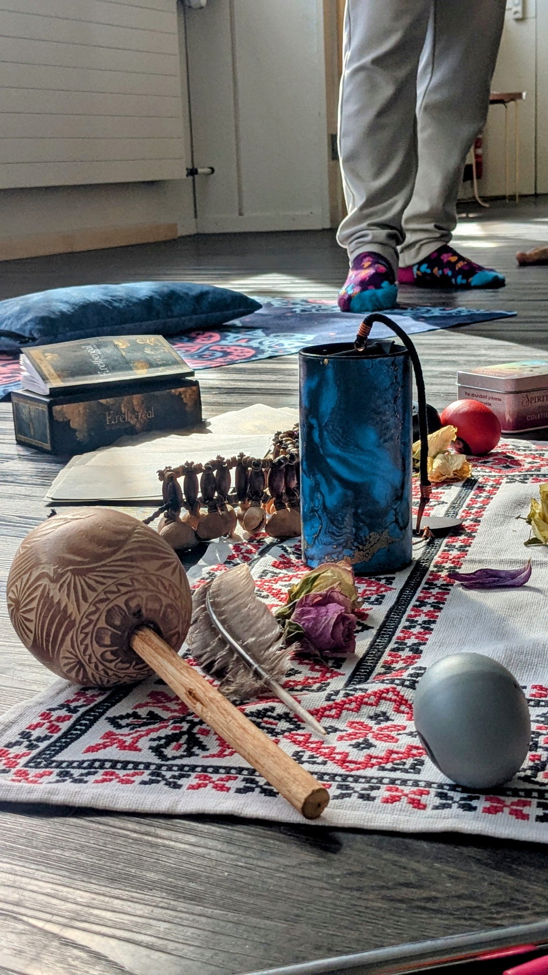 Shamanic rattle, feather and instruments arranged on a ceremony cloth