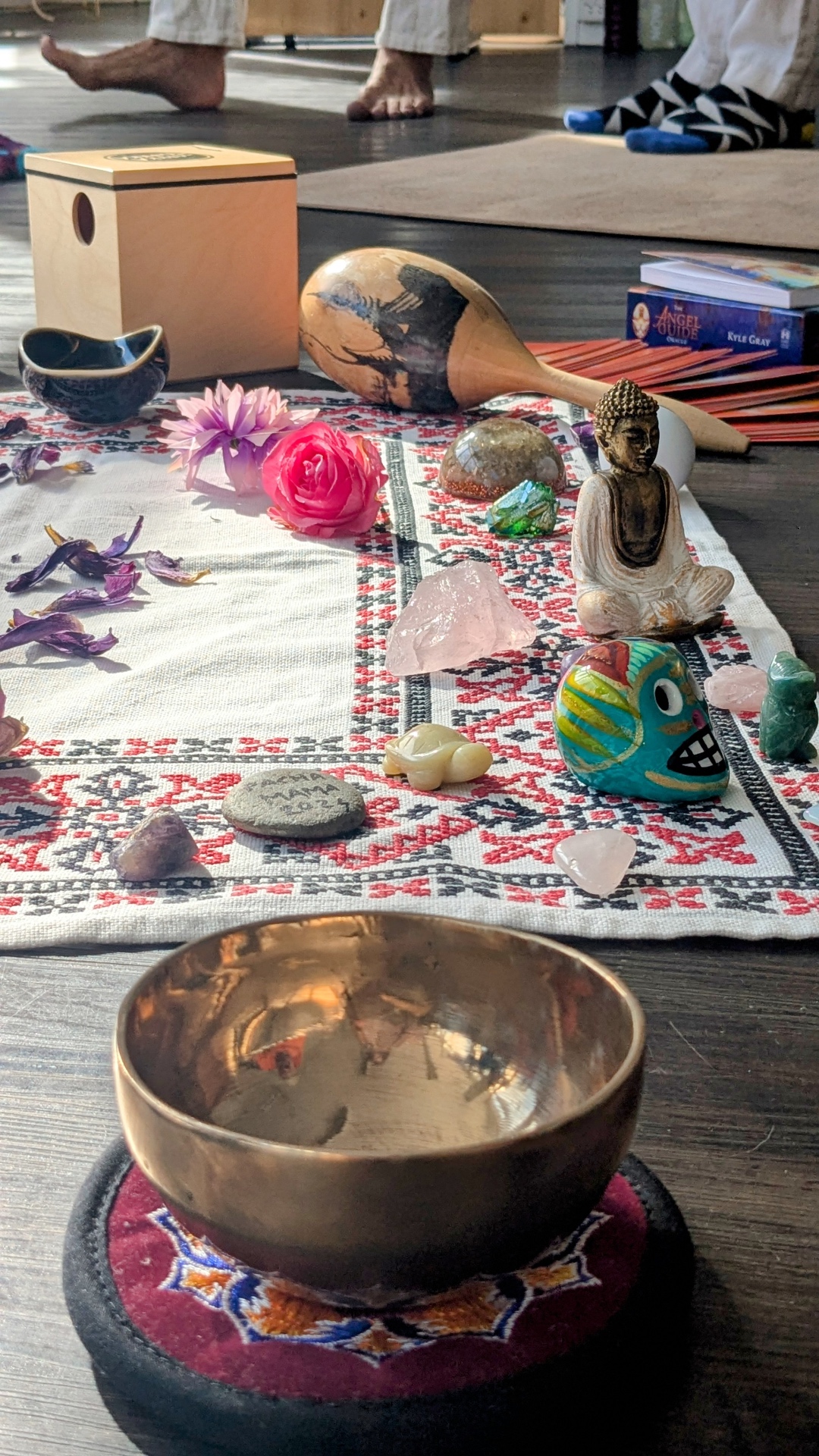 Ceremony altar with crystals, Buddha figure and singing bowl on a woven cloth
